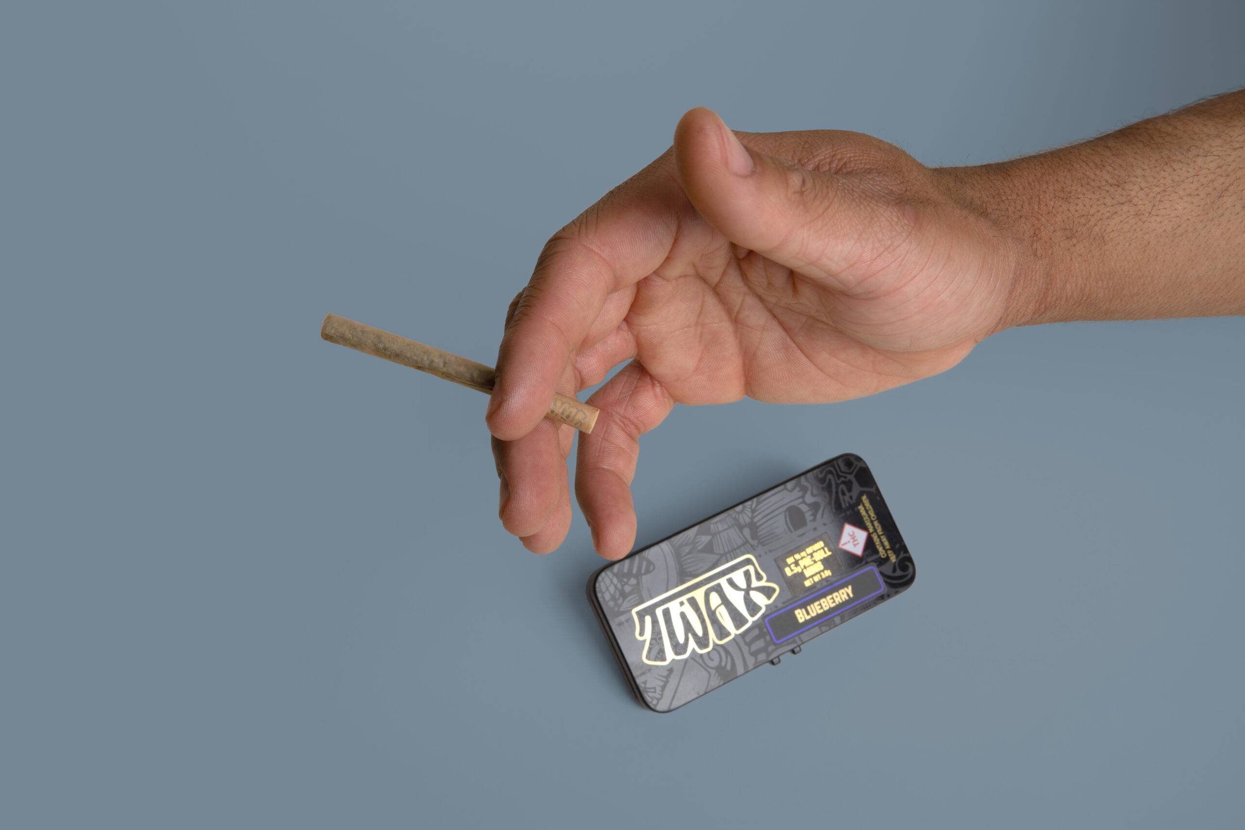 Hand holding cannabis joint