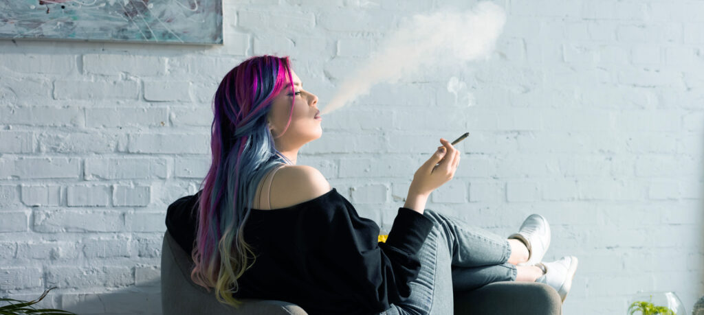 Popular Cannabis Strains in the USA: Types, Effects, and Top Picks for 2026 young adult woman smoking cannabis