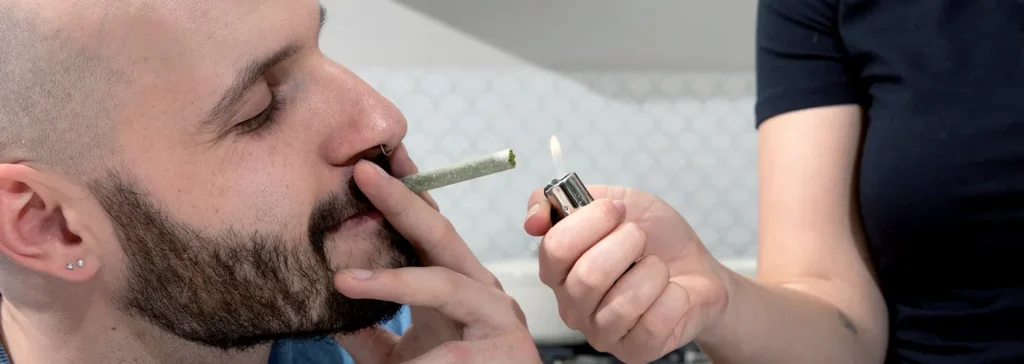 How to Choose Cannabis Strains for Pre-Rolls person lighting a joint